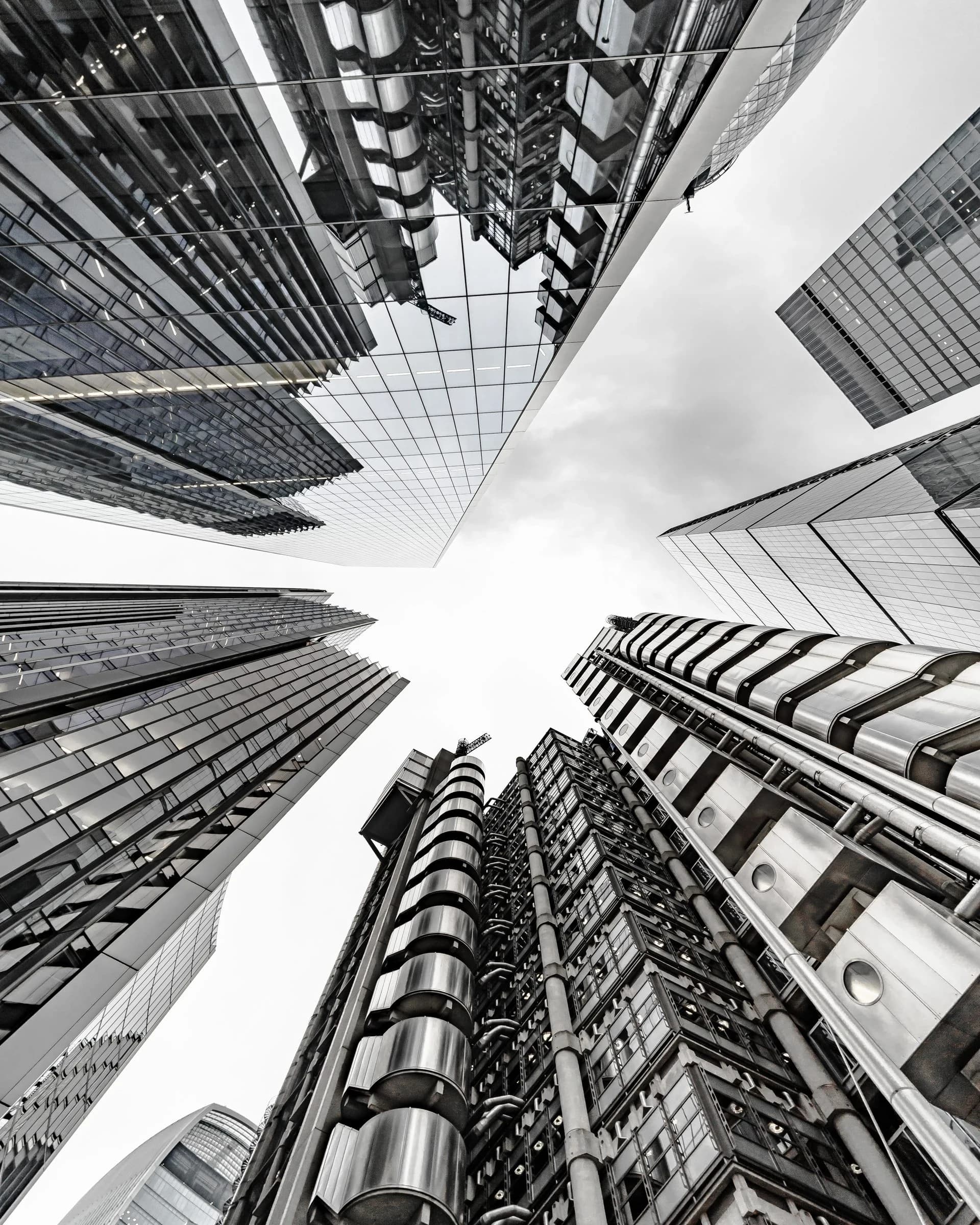 Upward view of a modern commercial tower against an open sky. Architectural textural anchor for the enterprise FM hero.